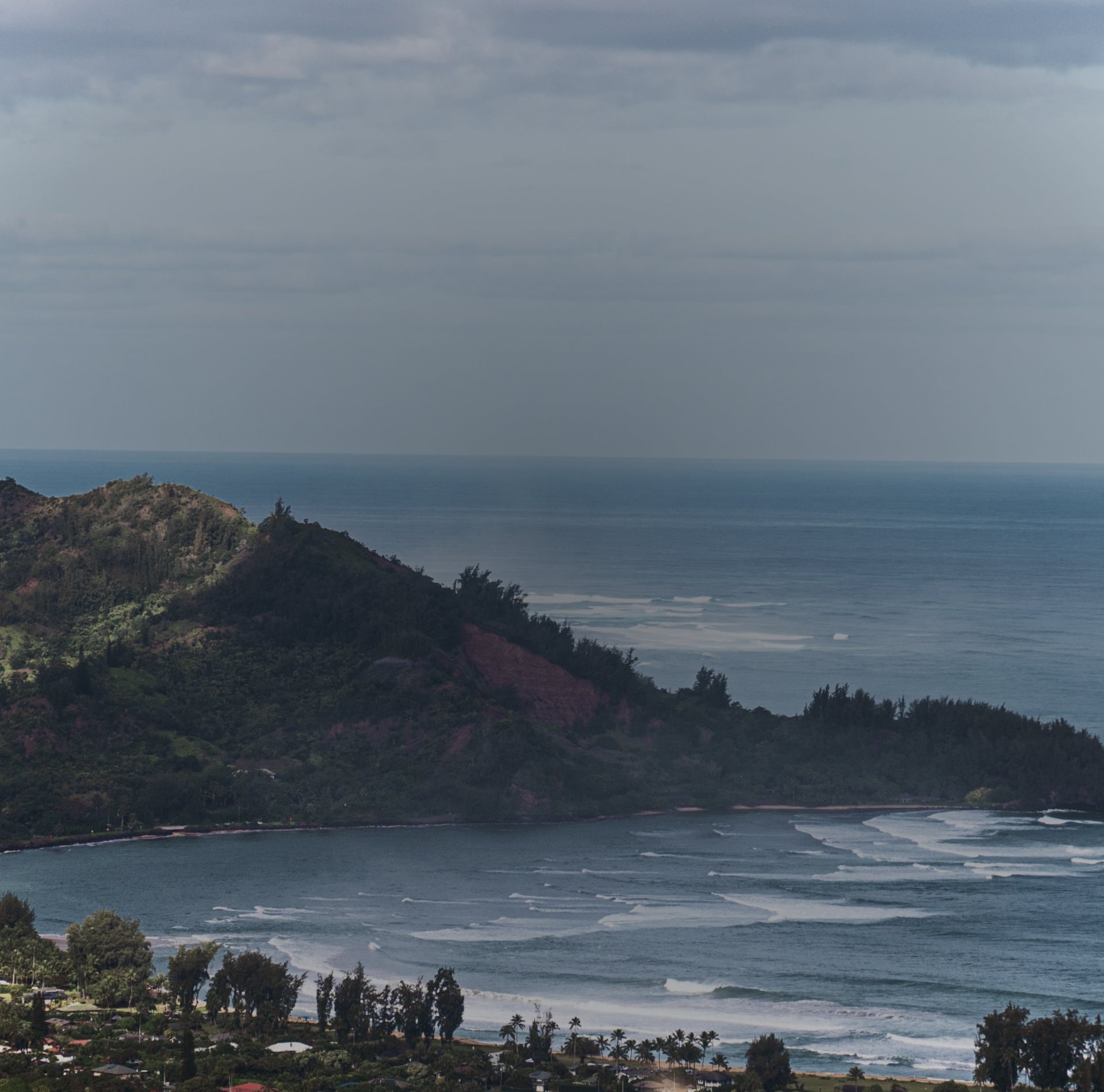 Coastal landscape with a hill, ocean, and cloudy sky