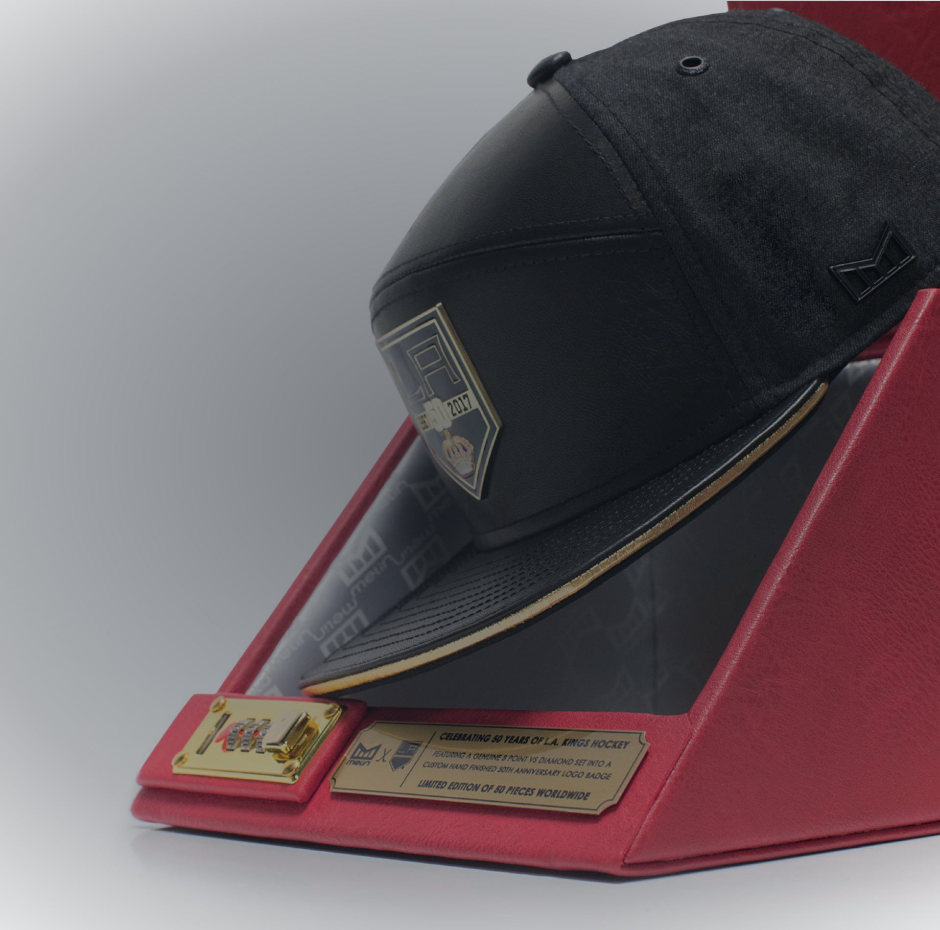Black cap with gold accents on a red and gray display stand