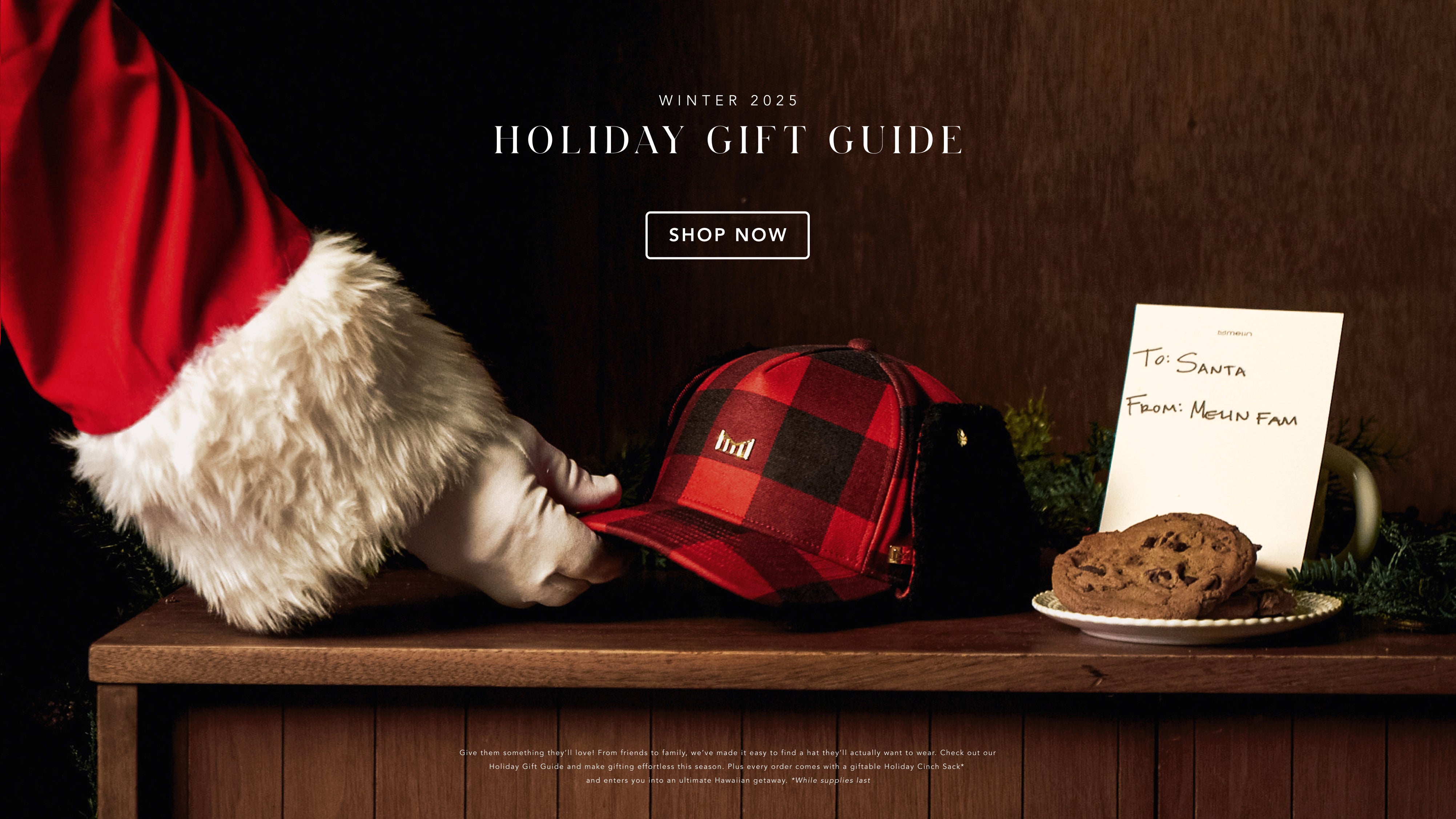 Santa Claus reaching for the Odysea Stacked Lumberjack Thermal on a wooden table with cookies and a letter, against a dark background, promoting the melin Gift Guide.