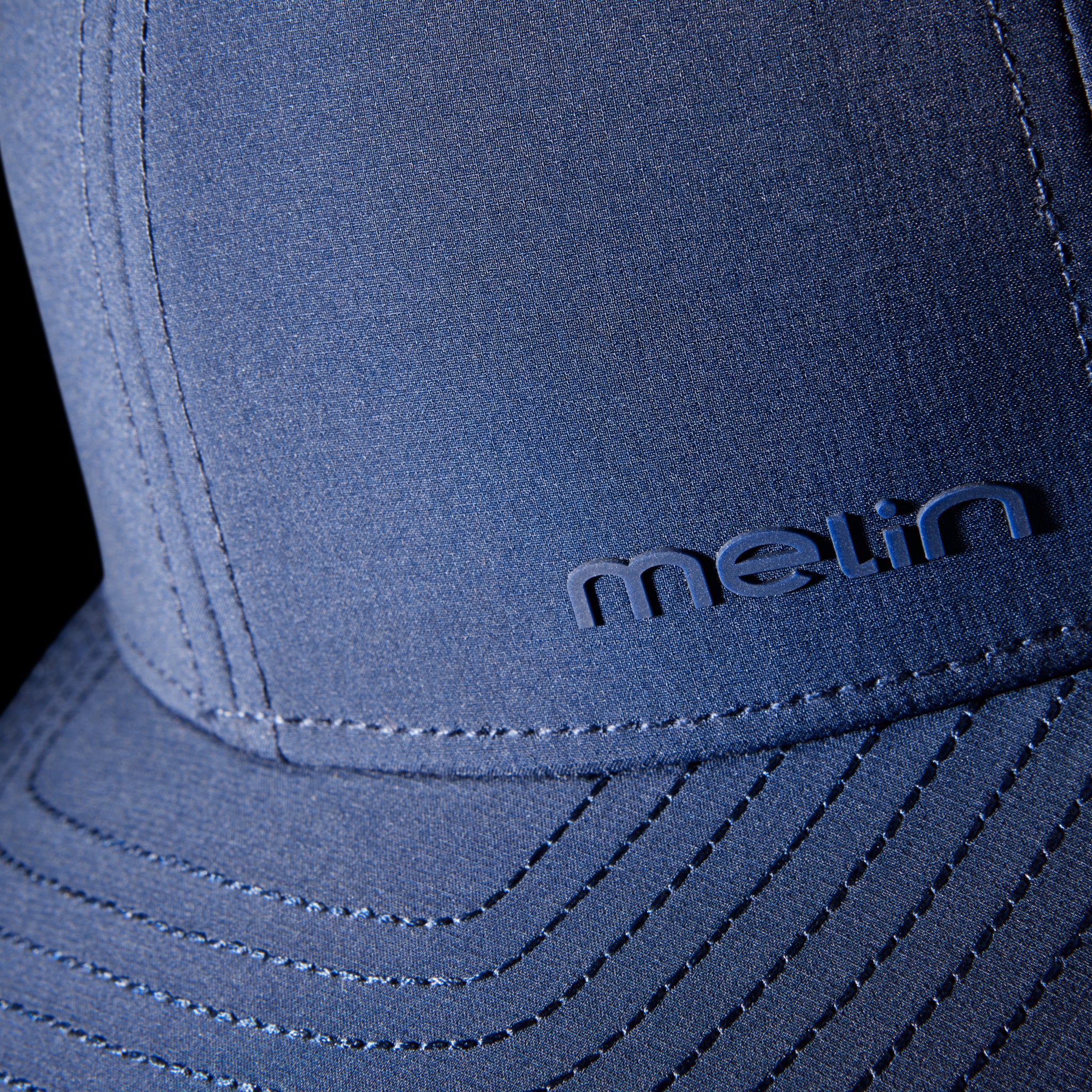 The close-up view of the melin Compass Hydro in Navy, featuring the branded melin logo across the left-hand side of the hat